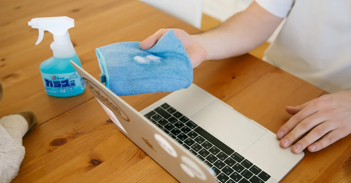 A cleaner carefully disinfecting a work surface